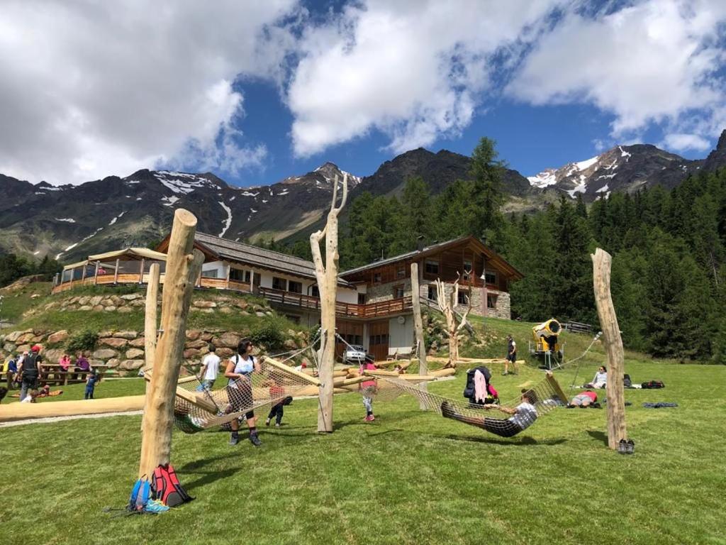 a group of people playing in a park with logs at Rifugio Lo Scoiattolo in Peio