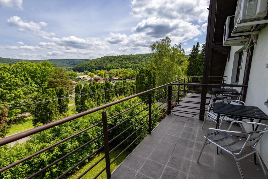 a balcony with chairs and a view of the mountains at Diás Panzió in Orfű