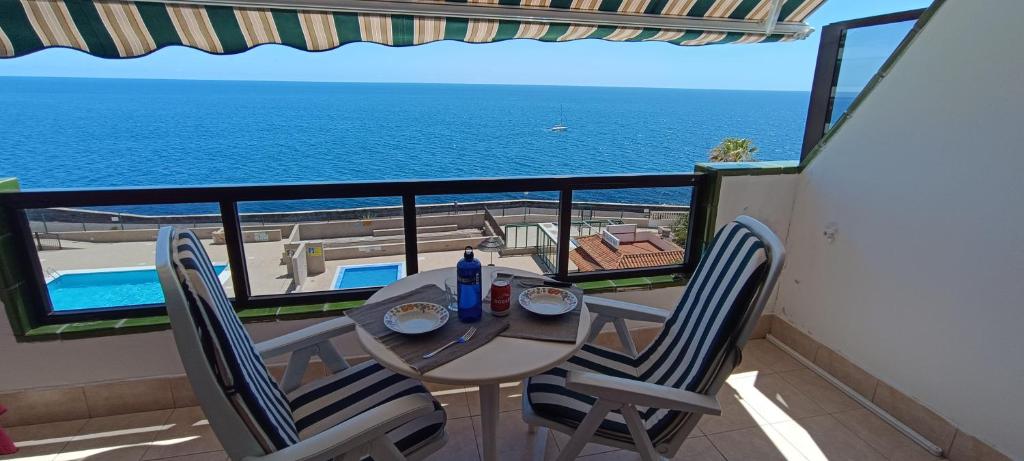a table and chairs with a view of the ocean at Ladybug Ocean View in Costa Del Silencio