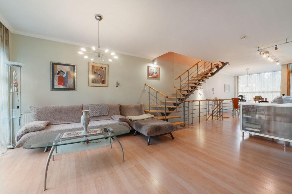 Una sala de estar con un sofá y una escalera. en Baltic Pine, en Jūrmala
