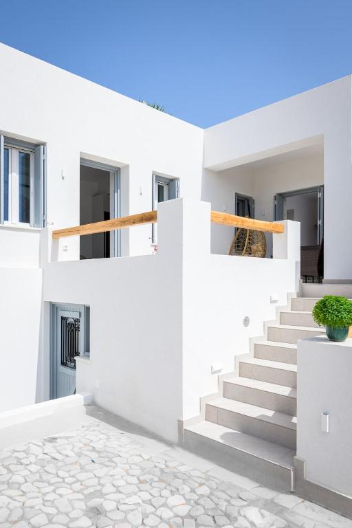 a white house with white stairs at Muca Houses in Triovasálos