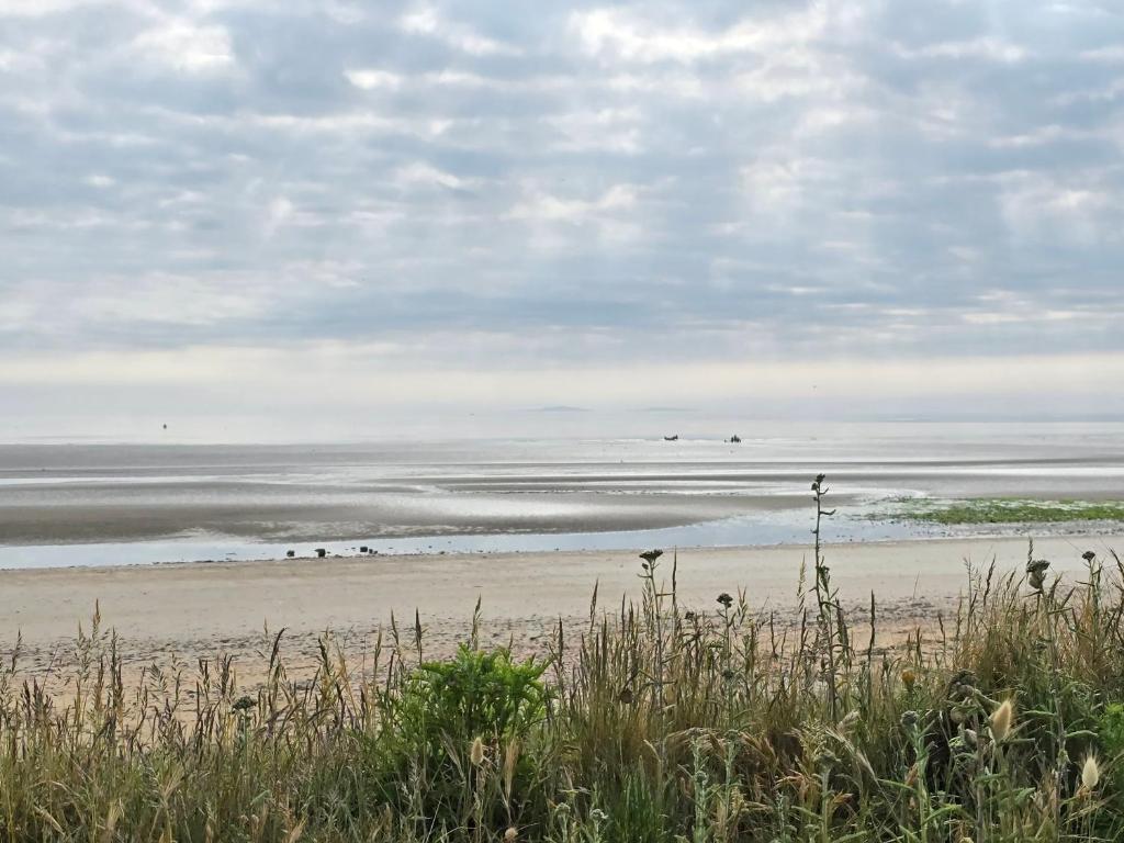 plaża z grupą ludzi na piasku w obiekcie Relais des îles Saint Marcouf w mieście Saint-Marcouf