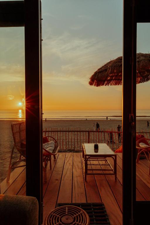 a view of the beach at sunset from a deck at Venti Beach Houses in Zandvoort