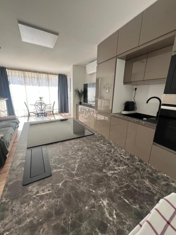 une cuisine et un salon avec un comptoir dans l'établissement Bleurivage - T3 - deux chambres bord de mer avec piscine et garage, à Sète