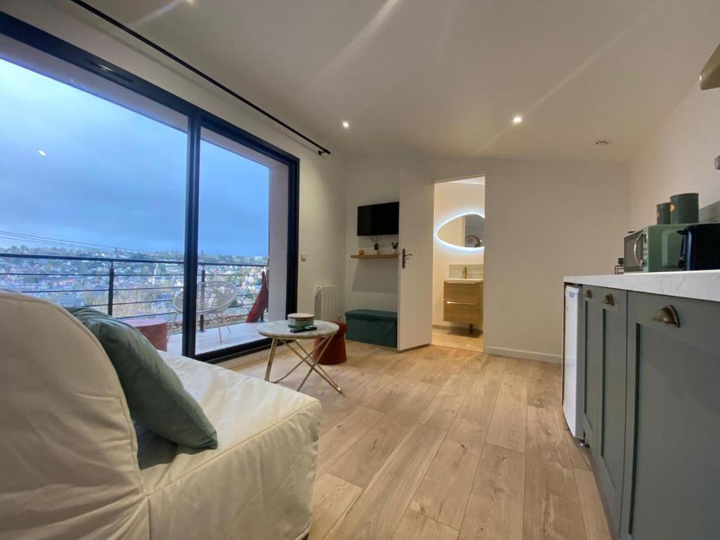 Il comprend un salon avec une grande fenêtre et une cuisine. dans l'établissement Petit havre de paix, à Rouen