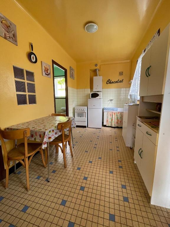 une cuisine avec une table et des chaises dans une pièce dans l'établissement Pyrenees studio view poolyer, à Ayzac-Ost