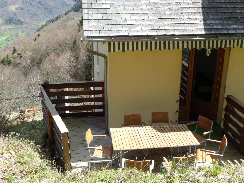 eine Veranda eines Hauses mit einem Tisch und Stühlen in der Unterkunft Appartement Les marmottes in Ilhan