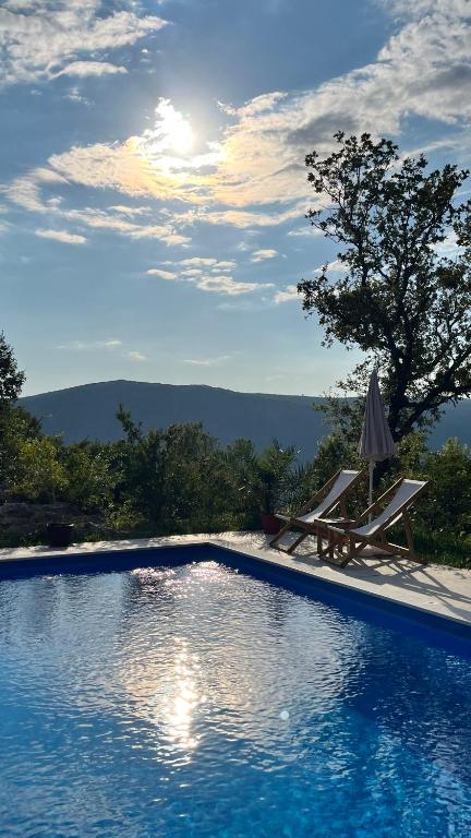a swimming pool with a table and a umbrella at Guesthouse P&A in Budva