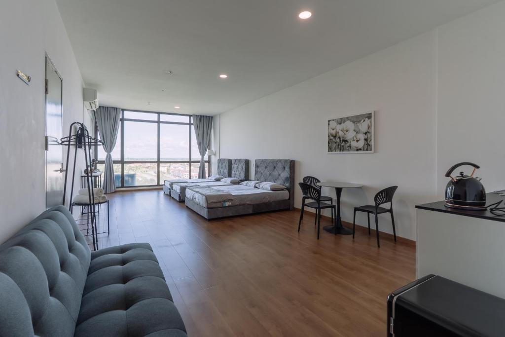 a living room with a couch and a table at SUMMER SUITES APARTMENT CASETTA HOMESTAY 3A at Kota Samarahan Kuching in Kuching