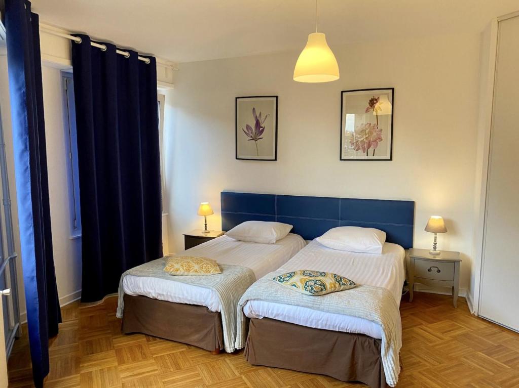 - 2 lits dans une chambre dotée de rideaux bleus dans l'établissement BUCER Strasbourg Parking, à Strasbourg