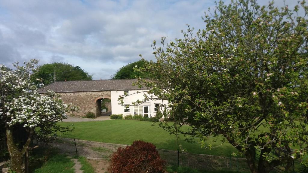 a white house with a yard with trees at Rectory Farm in Haverfordwest