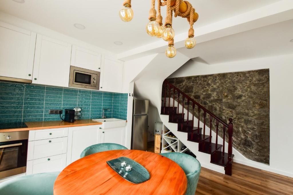 a kitchen with a wooden table and blue chairs at A Casa da Graça Reis by Horizon View Madeira in São Vicente