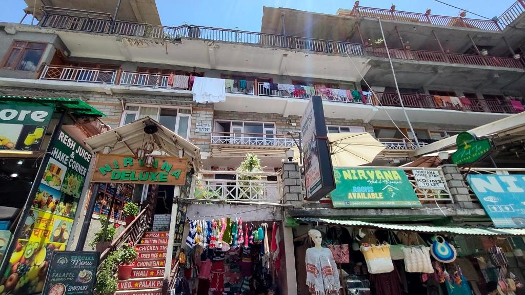 a building with a bunch of shops in front of it at Nirvana hotel , near by hot springs in manali bashisht in Vashisht