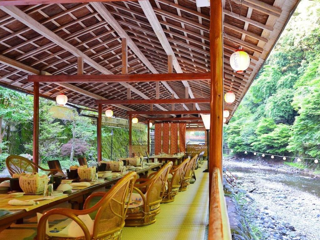 a dining car of a train with tables and chairs at Takao Kanko Hotel in Kyoto