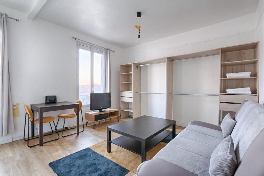 un salon avec un canapé et une table dans l'établissement Paul-Gillet Cosy Studio 2P, à Asnières-sur-Seine