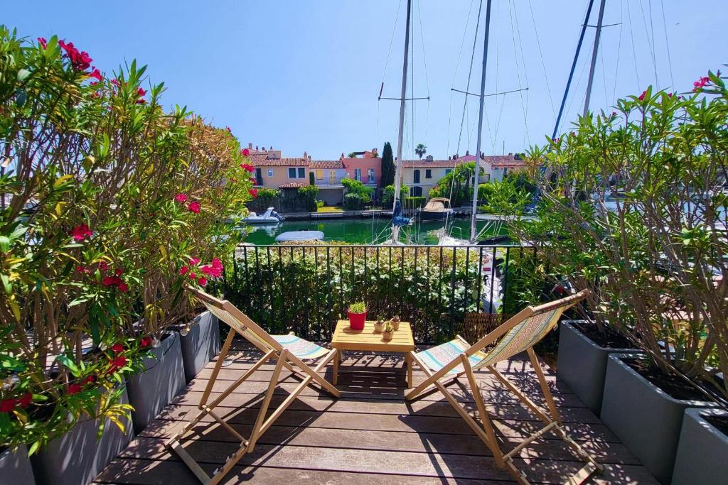 un patio avec deux chaises et une table et un bateau dans l'établissement Renovated 2 room apartment - AC WIFI and terrace, à Grimaud