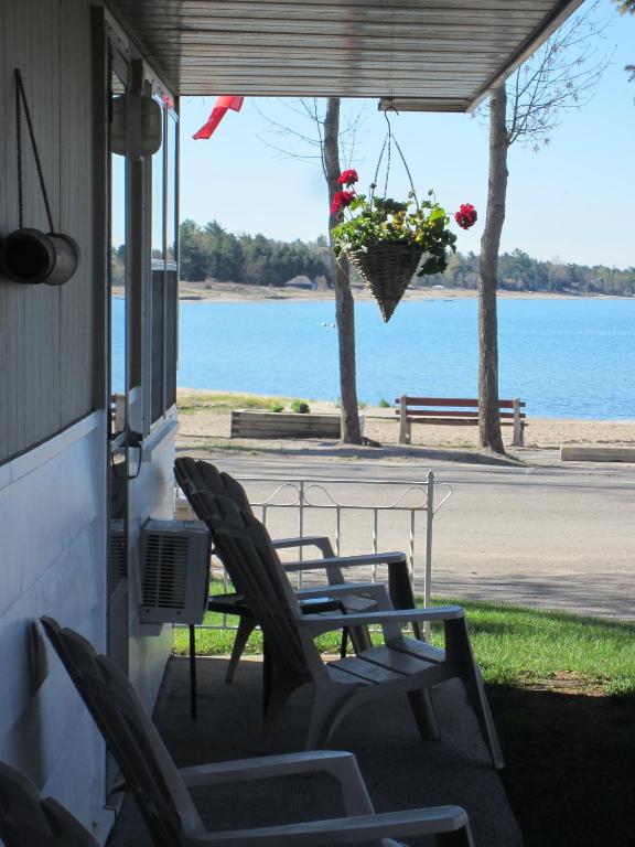 a porch with chairs and a hanging basket of flowers at Balm Beach Resort and Motel in Balm Beach