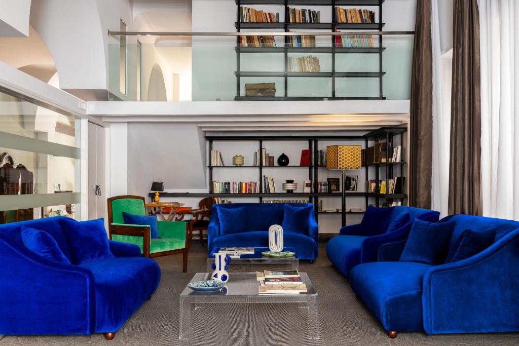 a living room with blue couches and a table at Hotel Principe Di Villafranca in Palermo