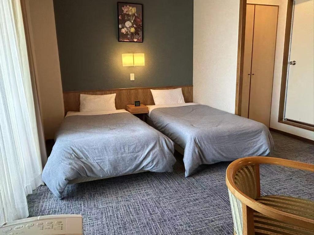 Postel nebo postele na pokoji v ubytování Shinnishiki Hotel