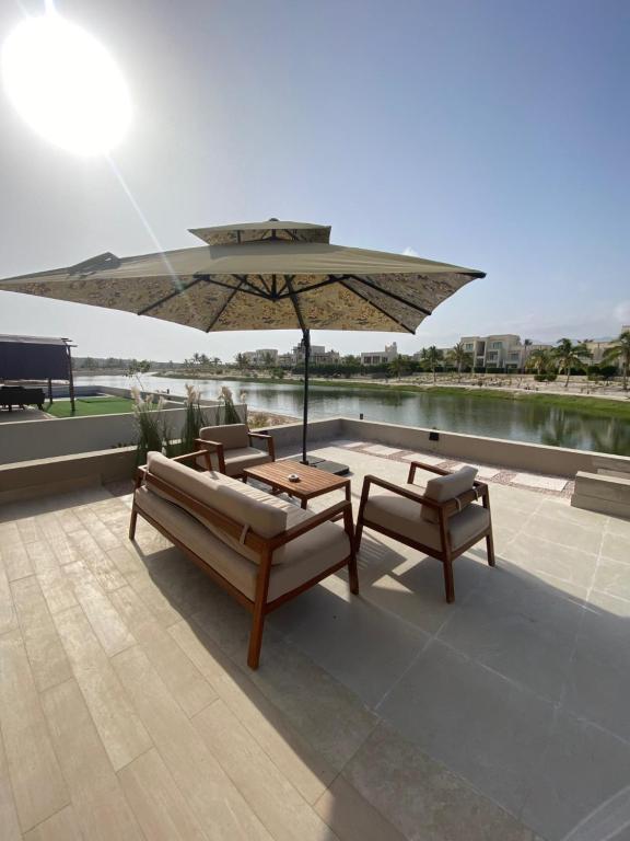 a patio with a table and chairs and an umbrella at Villa Rotana Tulip in Salalah