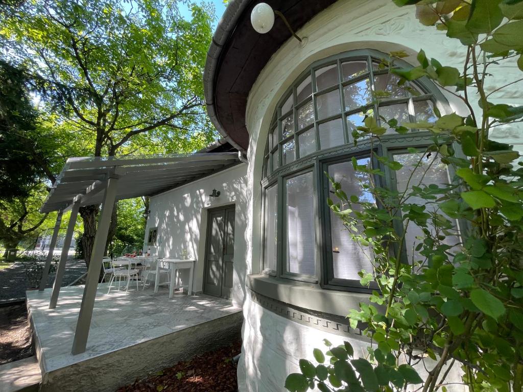 バラトンアカラッチャにある100 éves házの大きな窓のある白い家の外観