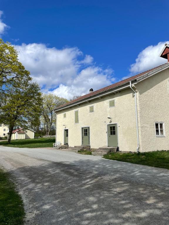 a white building with two doors on a street at Snickarboden - Cozy farmstay near forest & lake in Ingelstad