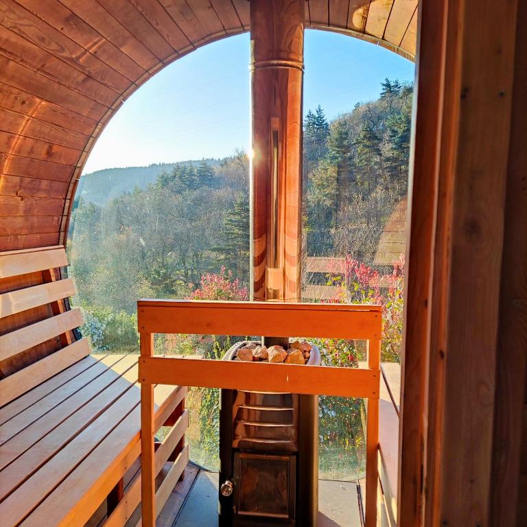 une pièce avec une fenêtre cintrée dans une cabine avec une table dans l'établissement Brin d'Ardèche, à Saint-Prix