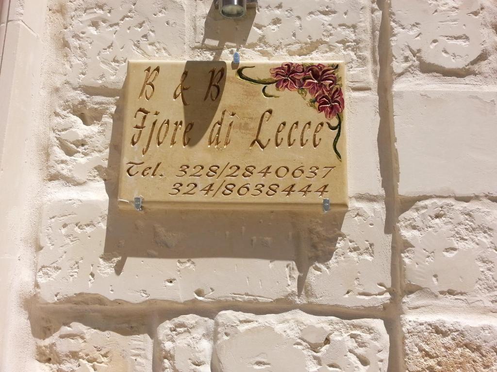 una señal en la pared de una pared de ladrillo en Fjore Di Lecce, en Lecce