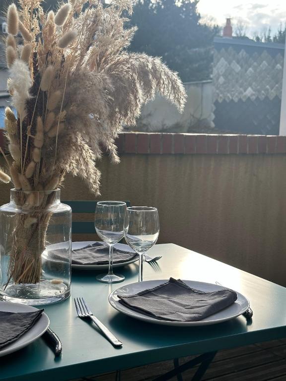 une table avec des assiettes et des verres et un vase avec des fleurs dans l'établissement Le Perchoir, au Tréport