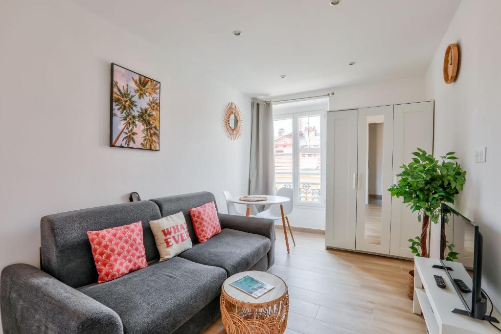 un salon avec un canapé et une télévision dans l'établissement Magnifique studio en plein centre de Nice, à Nice
