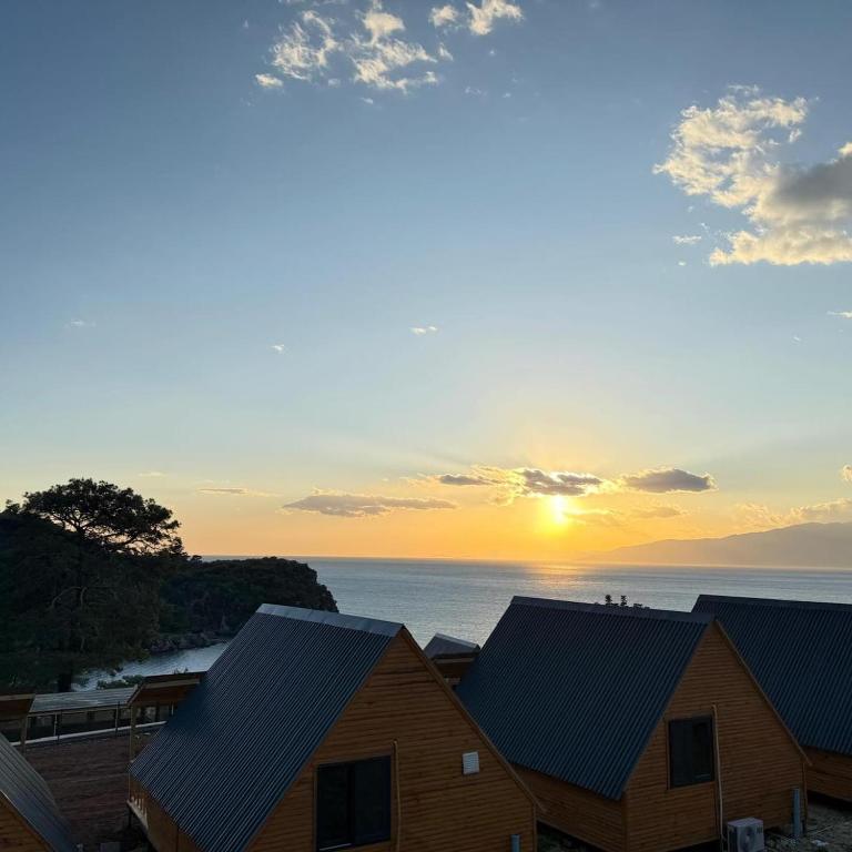 a house with the sunset in the background at Yelken Bungalows in Eskiömerler