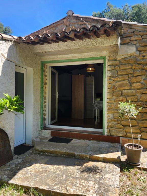 une maison en pierre avec une grande porte coulissante en verre dans l'établissement studio complet calme absolu, au Beausset