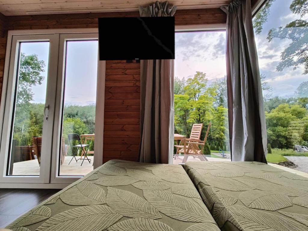 Un dormitorio con una cama y una ventana grande. en Wisla66 Domki nad Wisłą Piotrawin, 