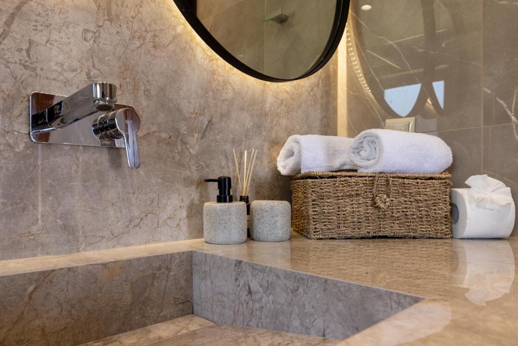 a bathroom with a counter with towels and a mirror at Villas Almyrida in Almyrida
