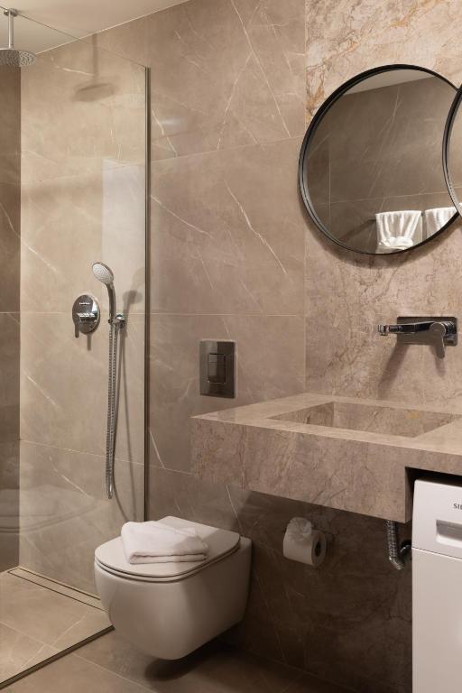 a bathroom with a shower and a toilet and a sink at Villas Almyrida in Almyrida