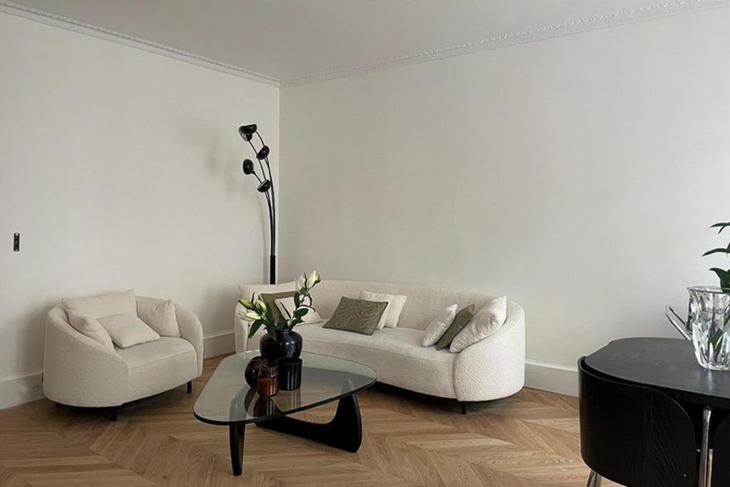 - un salon avec deux canapés blancs et une table dans l'établissement Spacious apartment with WiFi in the heart of Paris, à Paris