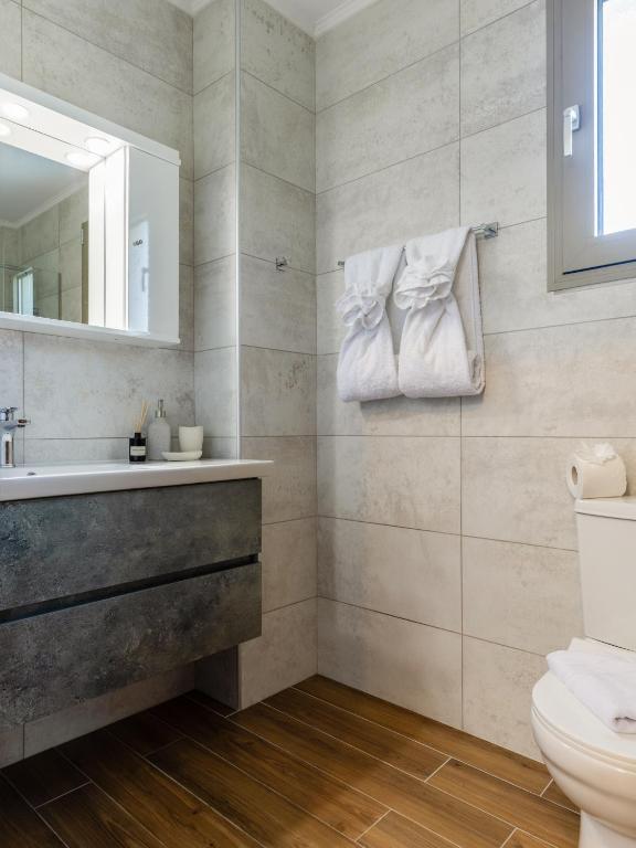 a bathroom with a sink and a toilet and a mirror at Villas Almyrida in Almyrida
