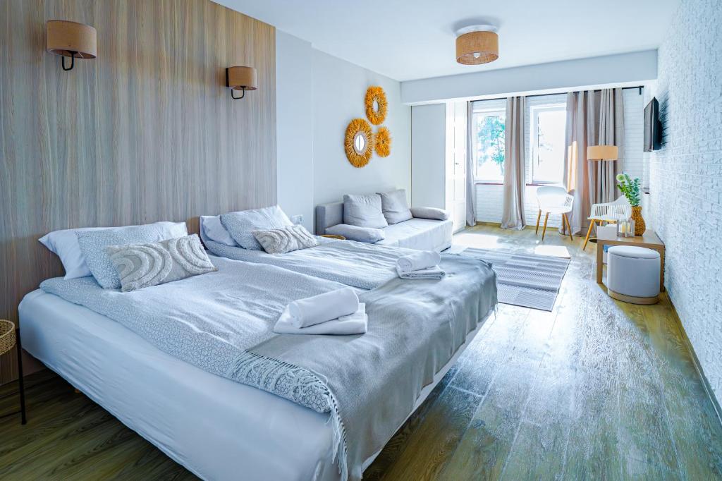 a bedroom with a large bed and a living room at Mazurskie Apartamenty "Jak Tu Miło!" in Węgorzewo