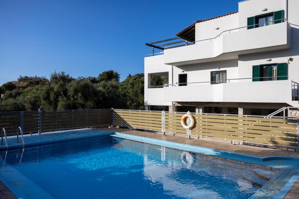 a villa with a swimming pool in front of a house at Villas Almyrida in Almyrida