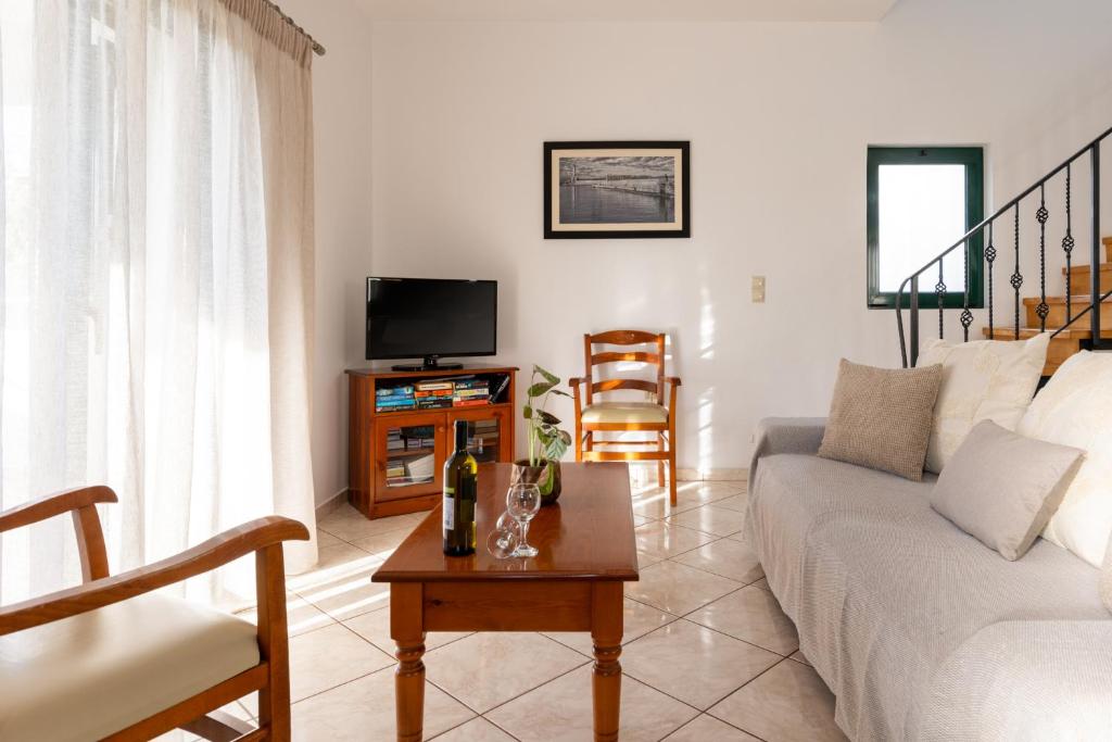 a living room with a couch and a tv at Villas Almyrida in Almyrida