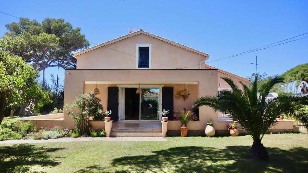 une maison avec un palmier devant dans l'établissement Maison de vacances proche plage de la Bergerie, à Hyères