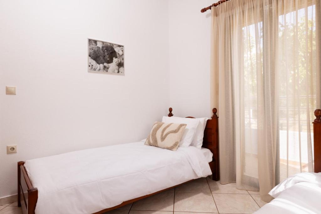 a white room with two beds and a window at Villas Almyrida in Almyrida