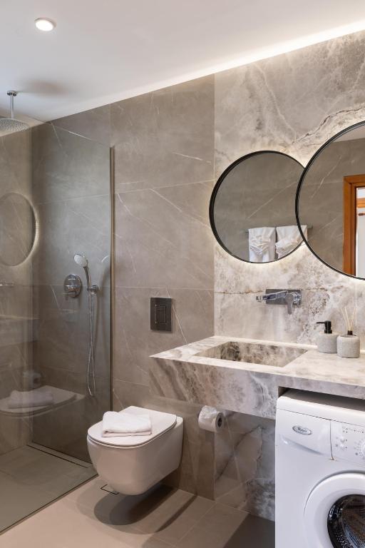 a bathroom with a toilet and a sink and a shower at Villas Almyrida in Almyrida