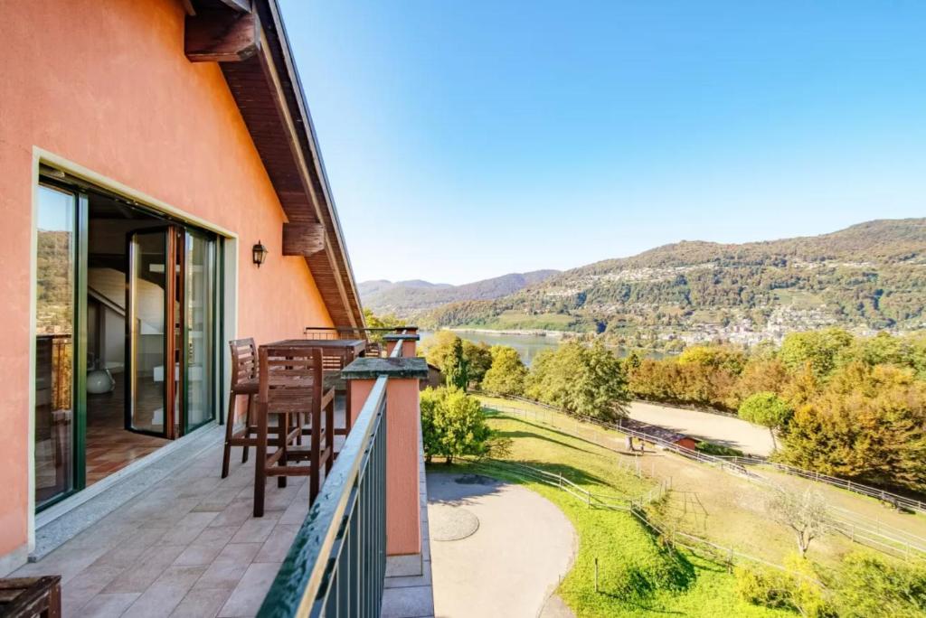 a balcony with chairs and a view of a river at Mansarda Gentilino by Quokka 360 - Charming attic retreat in nature in Collina d'Oro
