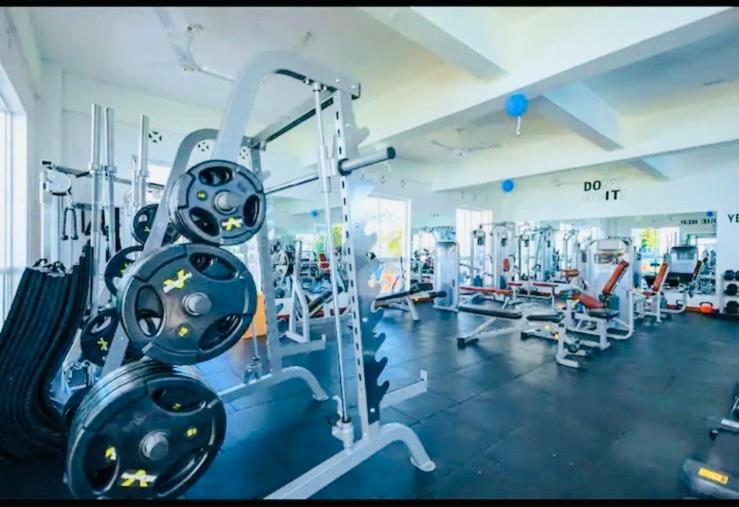 Un gimnasio con una gran sala con máquinas. en 1br CBD Pool Gym AirCon, washer, Wi-Fi, en Mombasa