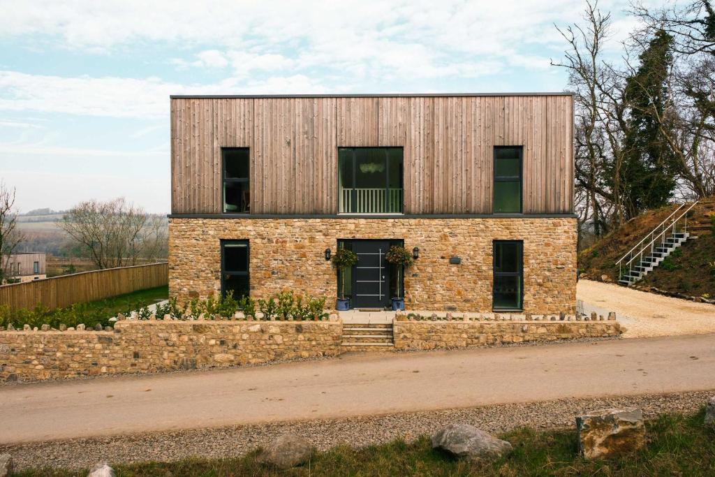 una casa de ladrillo sobre un muro de piedra en Brockview House - Eco 4 bed, en Holcombe