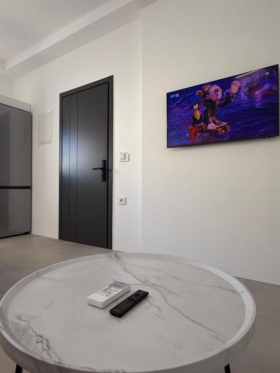 a white room with a table with a remote control on it at Drop off in Ermoupoli