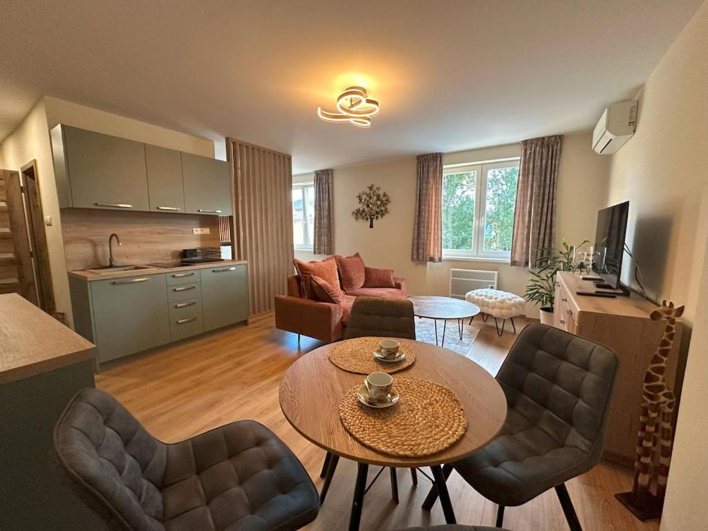 a living room with a table and chairs and a kitchen at Holiday apartment LARA in Šamorín in Šamorín