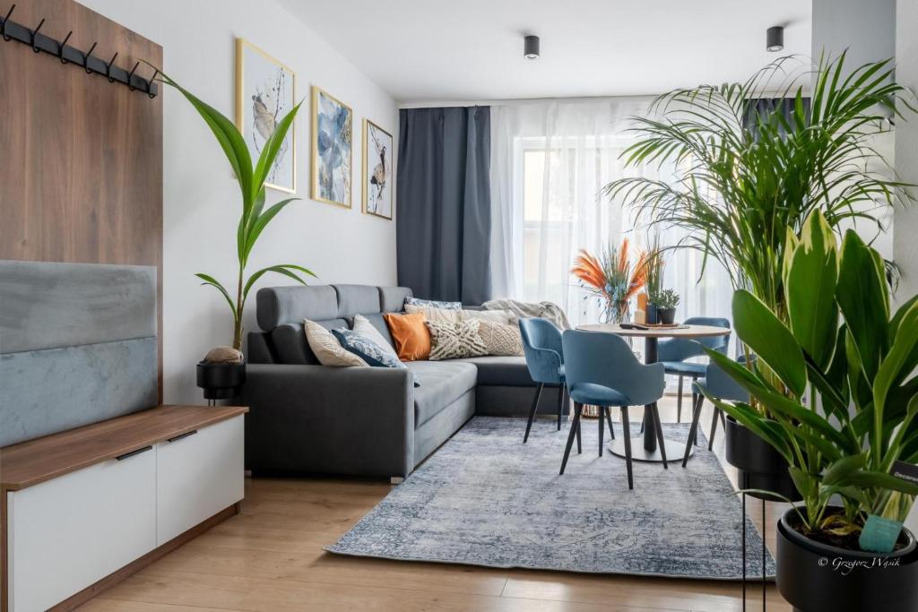 a living room with a couch and a table and chairs at Apartamenty Panorama 5! - Z widokiem, parkingiem, nowoczesne - wKarkonosze in Jelenia Góra