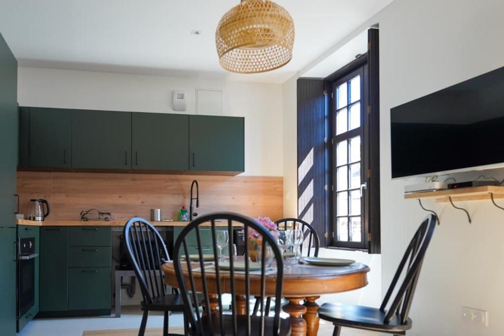 una cucina con tavolo, sedie e televisione di T3 cœur de ville avec climatisation a Brive-la-Gaillarde